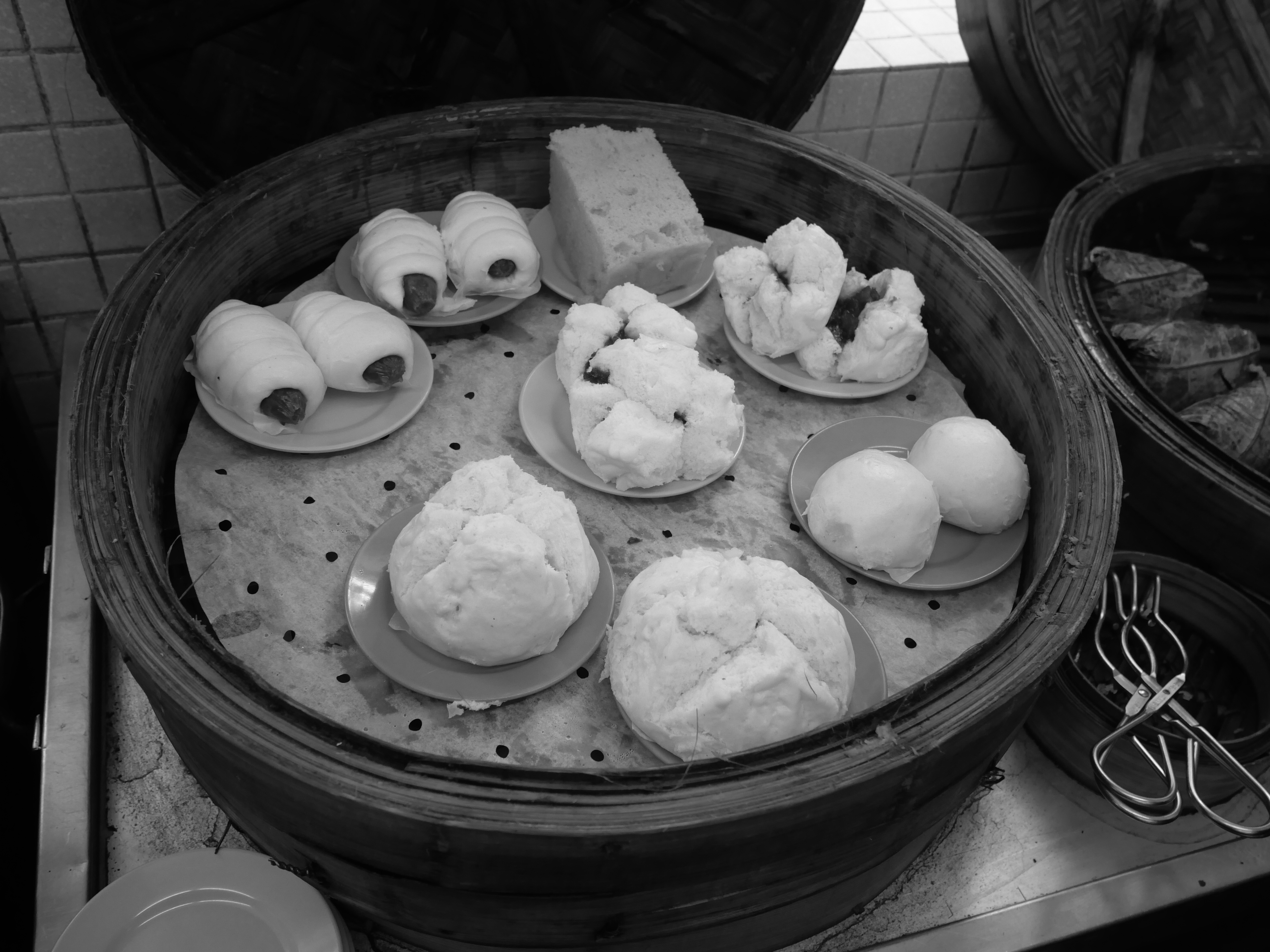 Dim sum dishes arranged on a restaurant table with tea and chopsticks